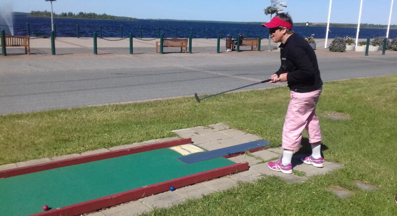 Henkilö pelaa minigolfia