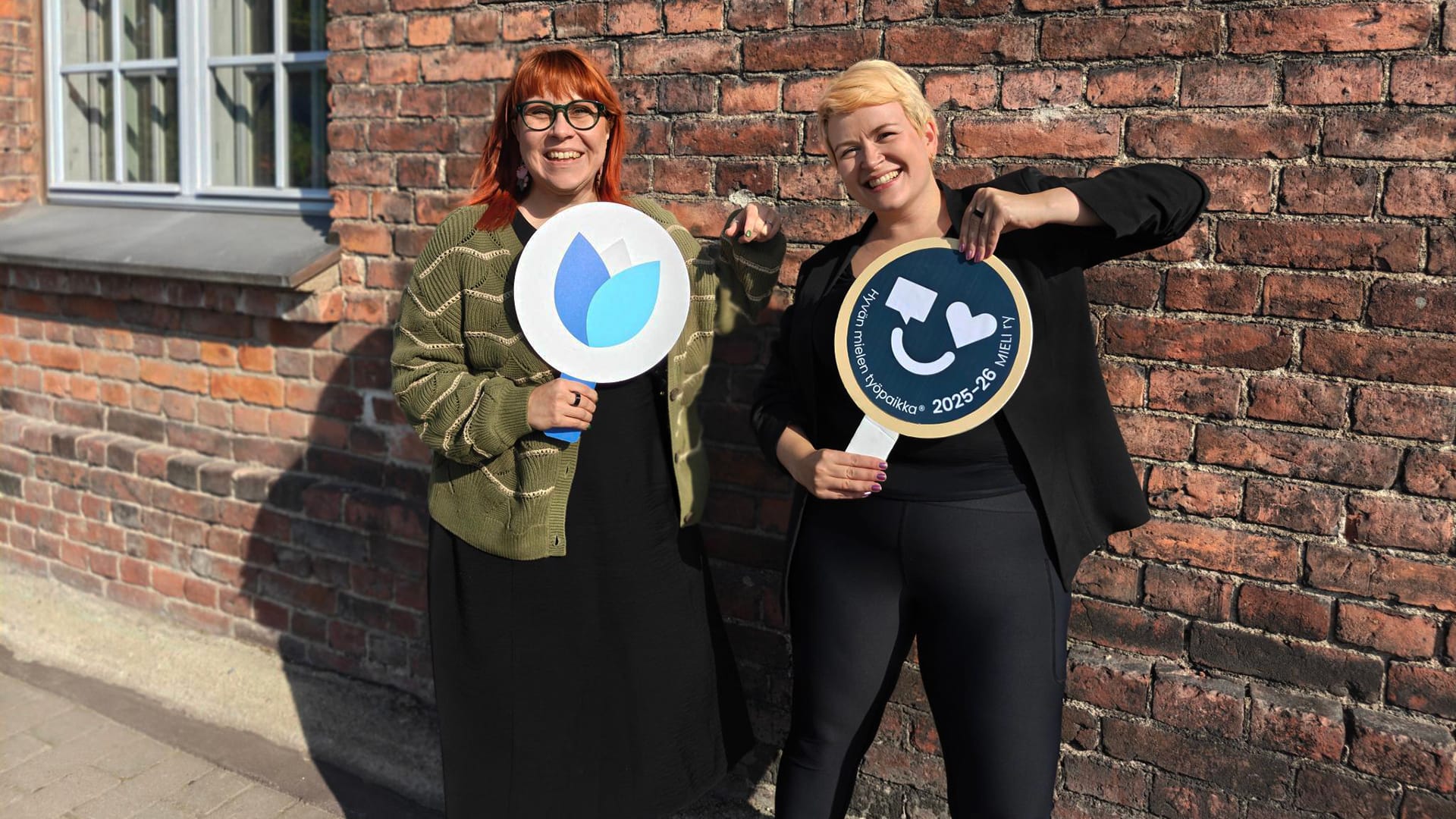 Työntekijöitä Hyvän mielen työpaikka -merkin kanssa