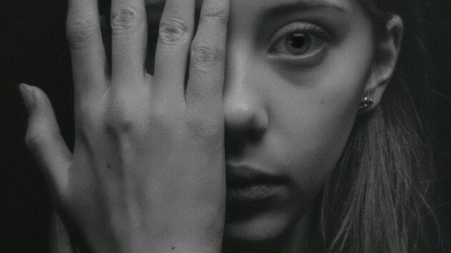 Nuori ja kädellä peitetyt kasvot