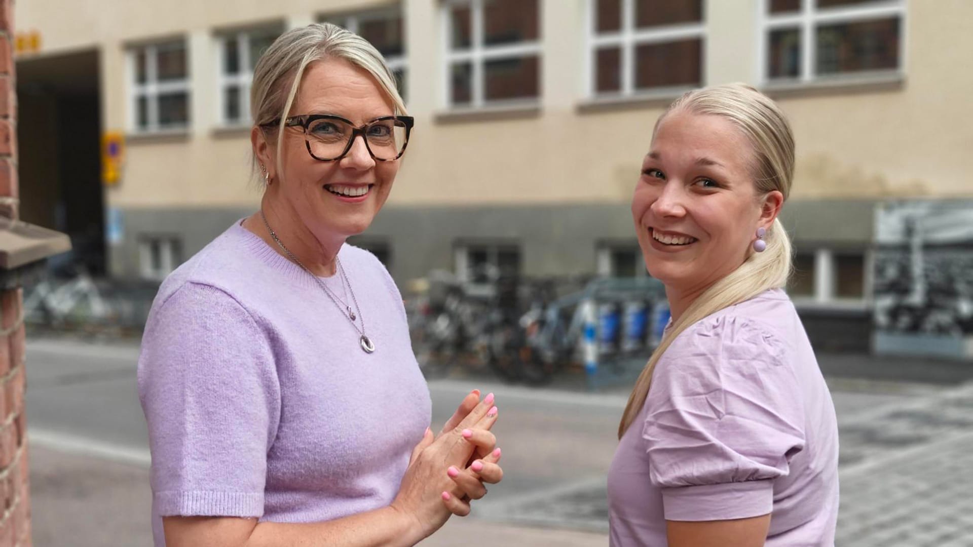 Kaksi Vanhemmuuden navigaattori -ryhmänohjaajaa hymyilee kameralle ulkona.
