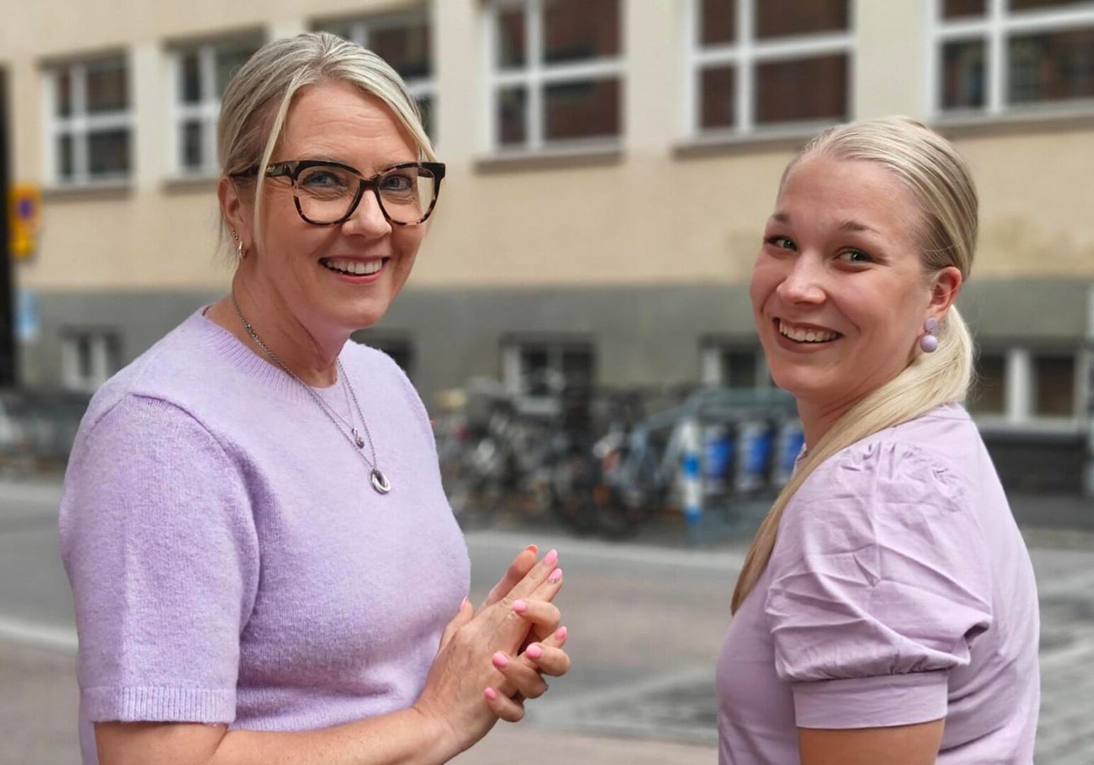 Kaksi Vanhemmuuden navigaattori -ryhmänohjaajaa hymyilee kameralle ulkona.